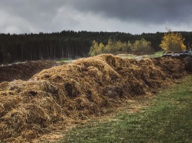 a large pile of hay is being loaded onto a tractor