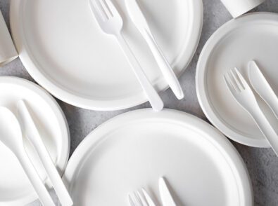 white paper plates with forks knives and spoons on them